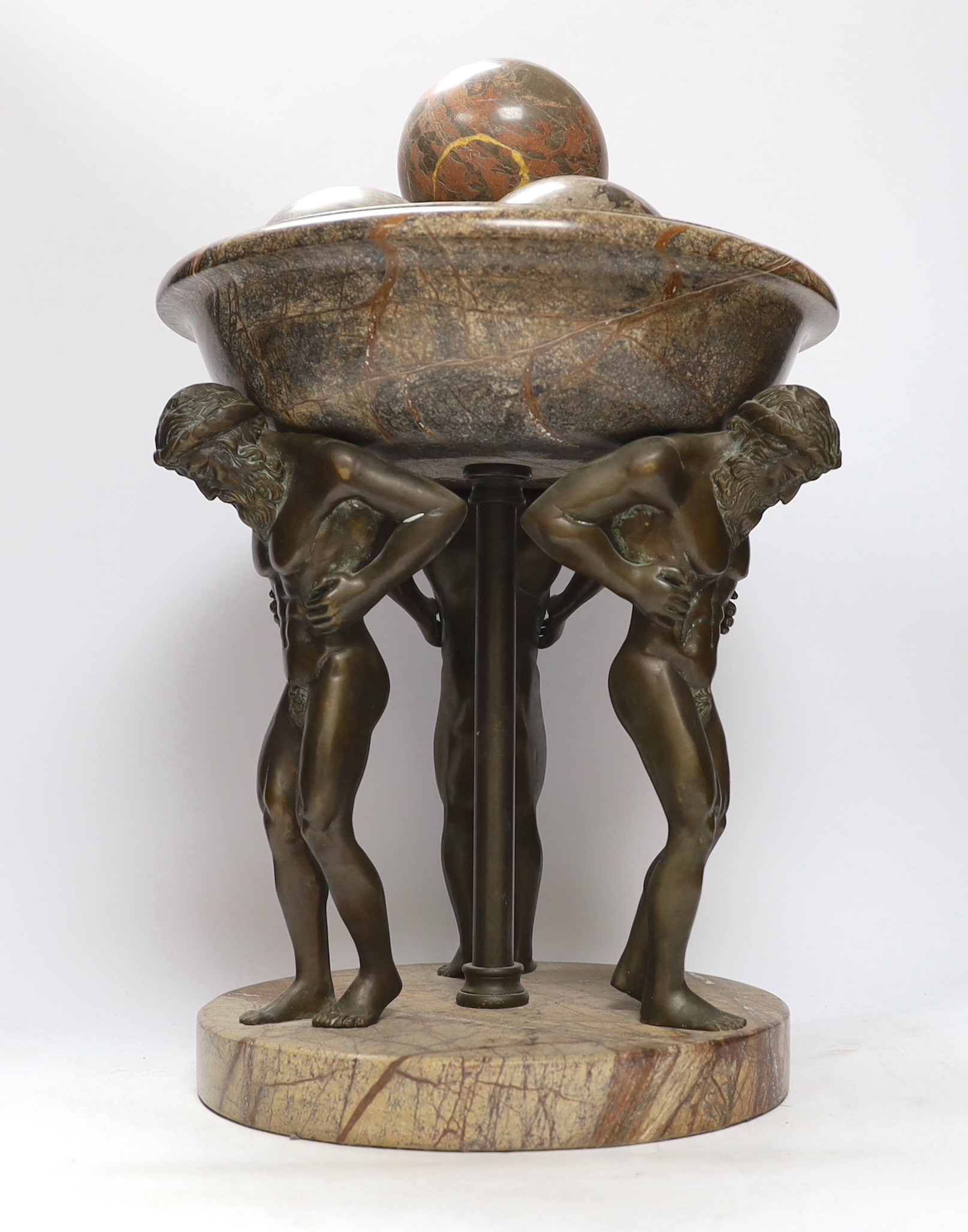 A reconstituted marble and bronzed metal Atlas tazza centrepiece with four stone spheres, 49cm high